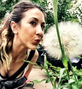 caitlin gordon blowing on a dandelion