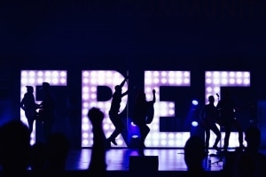 people dancing in front of LED sign that says "FREE"