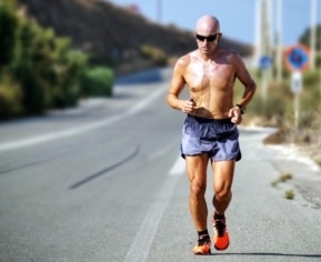 shirtless man jogging and sweating for detoxification