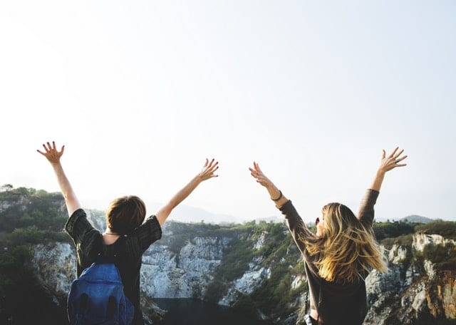 two people looking happy with arms in air