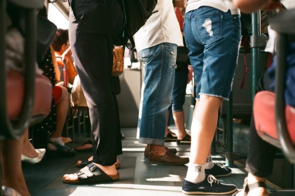 people's legs on a crowded subway train