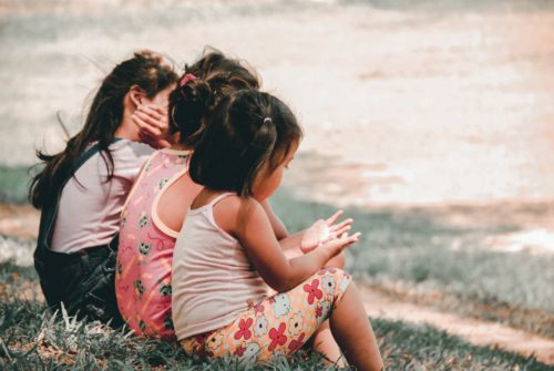 three little girls sitting next to each other