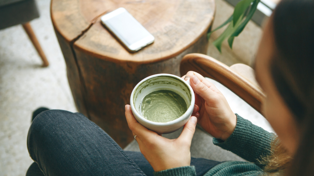 woman holding a cup of matcha green tea